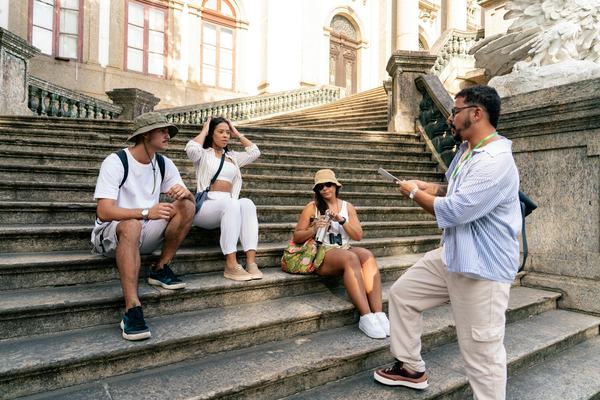 A guide talking to three travellers sitting on stone steps
